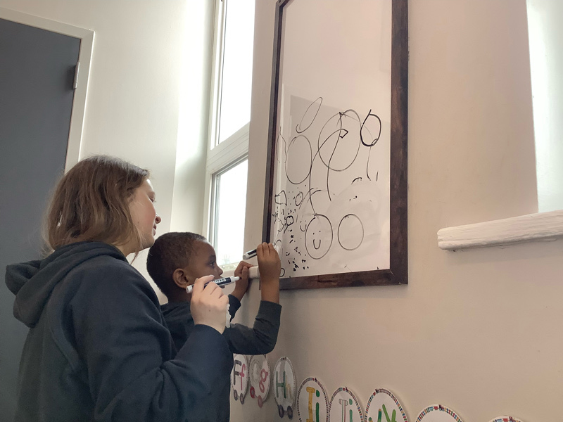 Eyas Landing child writing on whiteboard during evaluation