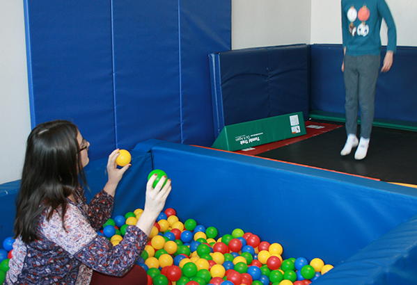 Eyas Landing therapist in ballpit tossing balls to a child